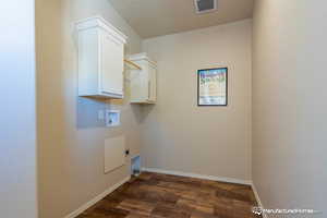 Washroom with electric dryer hookup, cabinets, washer hookup, and dark hardwood / wood-style floors