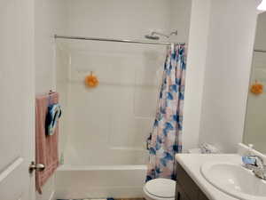 Master full bathroom featuring vanity, shower / bath combination with curtain, and toilet