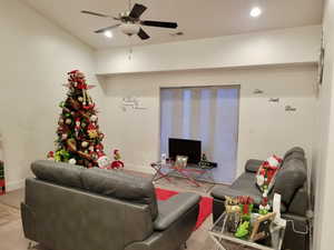 Carpeted living room with ceiling fan