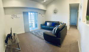 Carpeted living area featuring baseboards