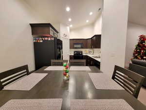 Dining space featuring sink and high vaulted ceiling