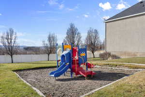 View of jungle gym with a lawn