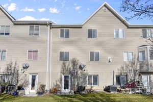 Rear view of property featuring central air condition unit and yard