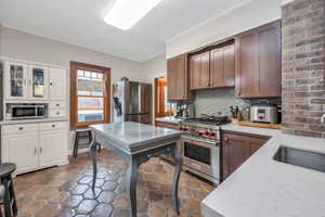 Kitchen featuring stainless steel appliances, sink, tasteful backsplash, and crown molding