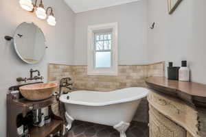 Bathroom with sink, a bath, tile walls, and tile patterned floors