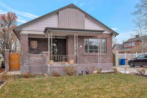 Bungalow-style house with a porch and a front lawn