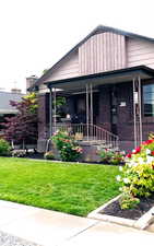 View of front of home with a porch and a front lawn