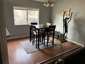 Dining room featuring wood-type flooring and an inviting chandelier