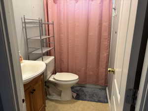 Bathroom featuring tile patterned floors, vanity, and toilet