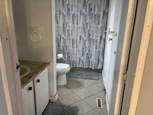 Bathroom featuring tile patterned flooring, vanity, and toilet