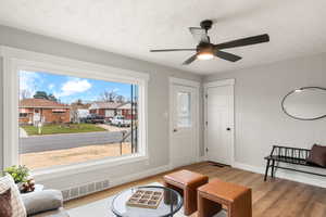 Living area with wood-type flooring, a textured ceiling, and ceiling fan