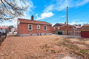 Rear view of property with central AC and a storage unit