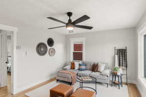 Living room with ceiling fan, a healthy amount of sunlight, and light wood-type flooring