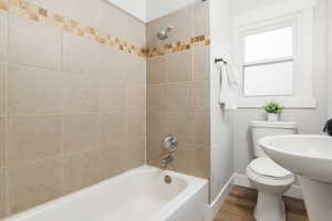 Upstairs Bathroom featuring LVP floors, toilet, and tiled shower / bath