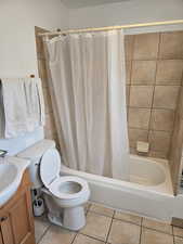 Full bathroom featuring tile patterned flooring, vanity, toilet, and shower / tub combo