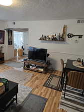 Living room featuring a textured ceiling and hardwood / wood-style flooring