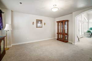 Empty room featuring light colored carpet