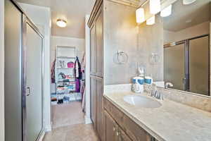 Bathroom with tile patterned flooring, vanity, and walk in shower