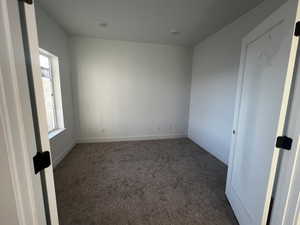 Spare room with dark colored carpet and plenty of natural light