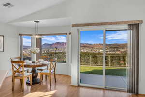 Dining area featuring a mountain view, lofted ceiling, a wealth of natural light, and light hardwood / wood-style flooring