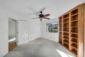 Unfurnished room with ceiling fan and light colored carpet