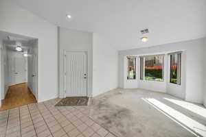 Foyer entrance featuring lofted ceiling and light tile patterned floors