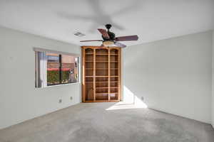 Empty room featuring ceiling fan and light colored carpet