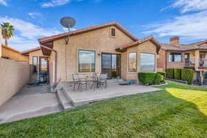 Rear view of house with a yard and a patio area