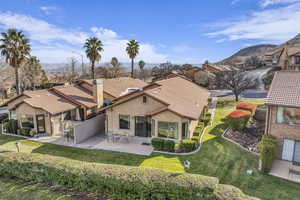 Rear view of property featuring a lawn and a patio area