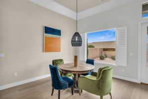 Dining room with ornamental molding and wood-type flooring