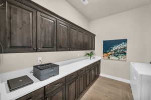 Laundry room with light hardwood / wood-style flooring, cabinets, and independent washer and dryer