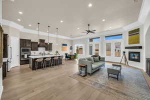 Living room with light wood-type flooring, french doors, ceiling fan, and sink