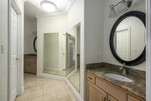 Bathroom with vanity, tile patterned floors, and crown molding