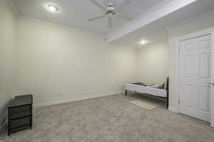 Bedroom featuring ceiling fan, light carpet, and ornamental molding