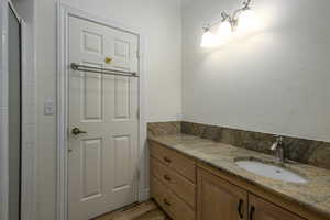 Bathroom with hardwood / wood-style floors, vanity, and a shower with door