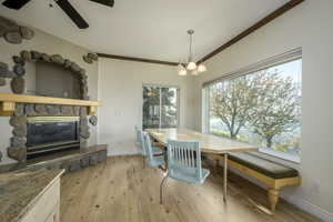 Dining space featuring light wood-type flooring, a fireplace, a wealth of natural light, and ornamental molding