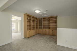 Empty room featuring ceiling fan, light colored carpet, and ornamental molding