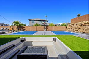 Exterior space featuring basketball hoop and a lawn