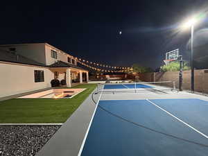 View of sport court with a yard and tennis court