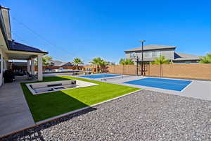 View of sport court with tennis court and a yard