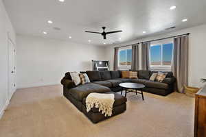 Carpeted living room with ceiling fan