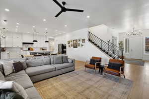 Living room featuring light hardwood / wood-style flooring and ceiling fan with notable chandelier