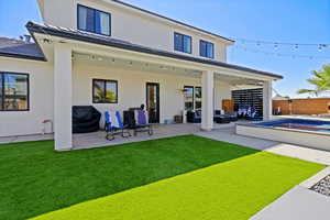 Rear view of house featuring an outdoor living space, a pool, a patio area, and a lawn