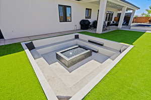 View of patio featuring a swimming pool and an outdoor living space with a fire pit