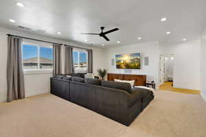 Living room featuring ceiling fan and light carpet