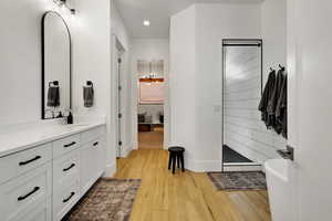 Bathroom featuring vanity, wood-type flooring, and walk in shower