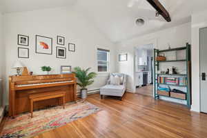 Sitting room with a baseboard heating unit, light hardwood / wood-style flooring, and lofted ceiling