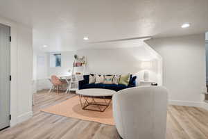 Living room with light hardwood / wood-style floors and a textured ceiling