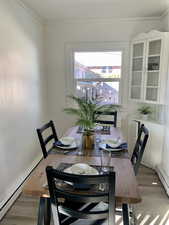 Dining area featuring light hardwood / wood-style floors, ornamental molding, and baseboard heating