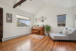 Sitting room featuring a baseboard radiator, track lighting, hardwood / wood-style flooring, and lofted ceiling